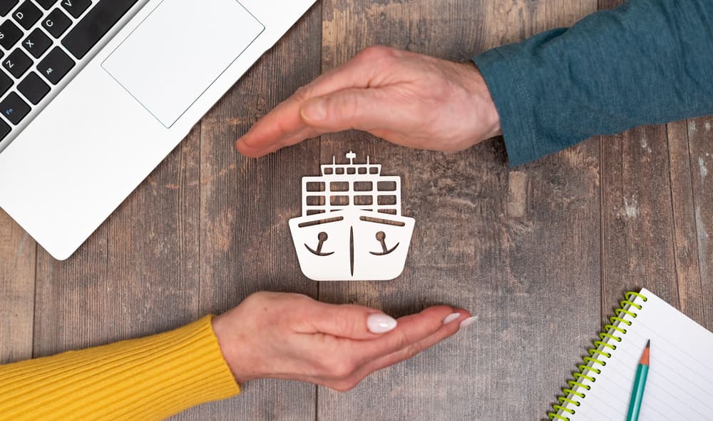 An image of a boat with two hands around it to symbolize boat insurance.